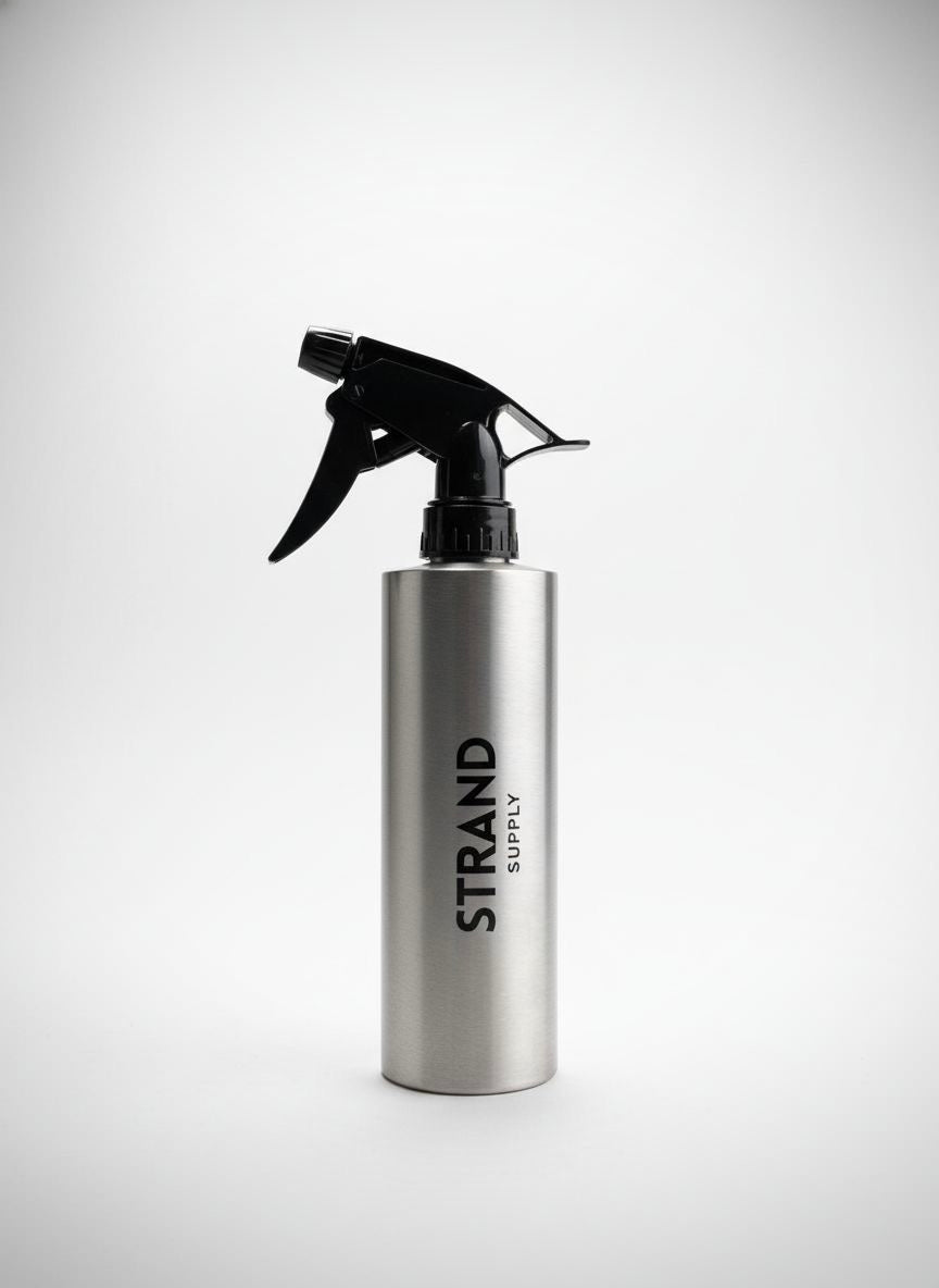 Silver spray bottle with black nozzle on a white background, featuring 'Strand Supply' branding.