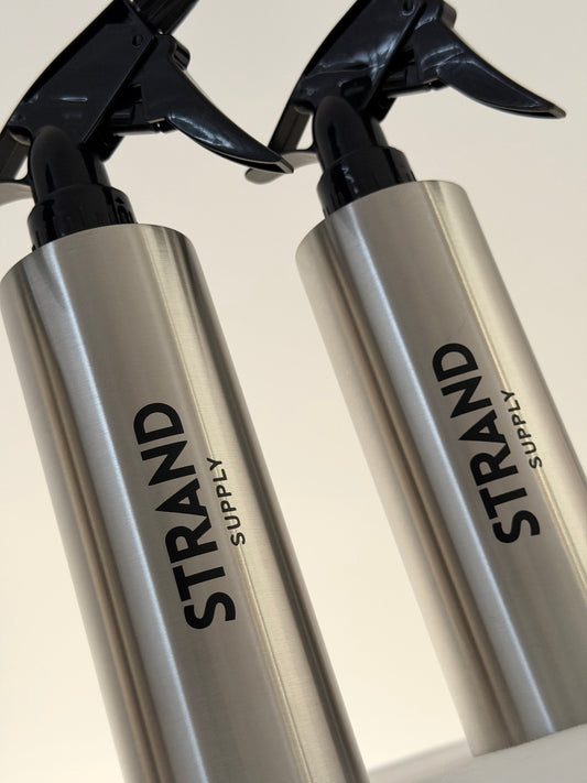 Stainless steel spray bottle on a barber workstation